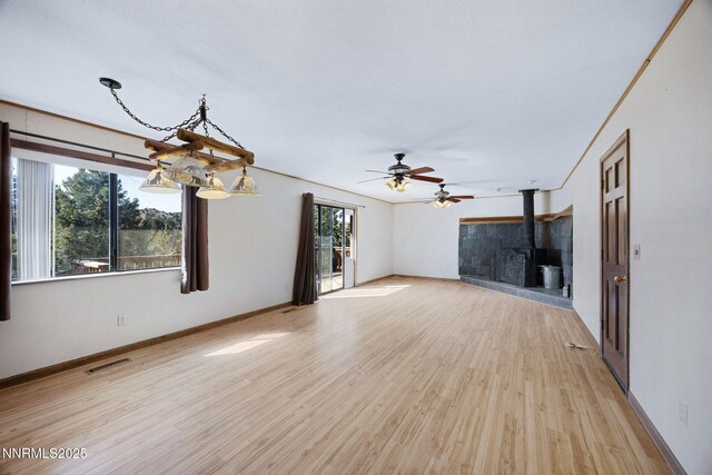 2260 Empire Rd, Reno, NV 89521 - unfurnished living room featuring light wood finished floors, a wood stove, and a ceiling fan