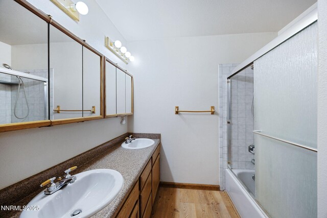2260 Empire Rd, Reno, NV 89521 - bathroom with wood finished floors, double vanity, and bath / shower combo with glass door