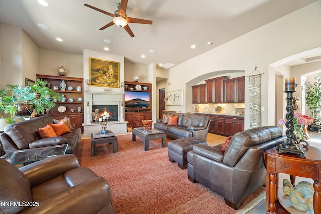 3970 Nature Trl, Reno, NV 89511 - living room featuring ceiling fan, recessed lighting, a glass covered fireplace, light carpet, and arched walkways