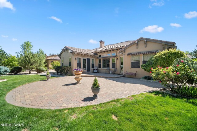 3970 Nature Trl, Reno, NV 89511 - back of property featuring a chimney, a patio area, stucco siding, and a yard