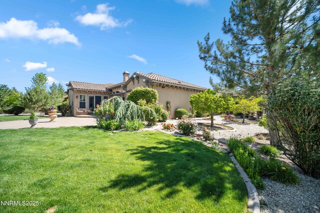3970 Nature Trl, Reno, NV 89511 - back of property featuring stucco siding, a lawn, a chimney, a patio area, and a tile roof