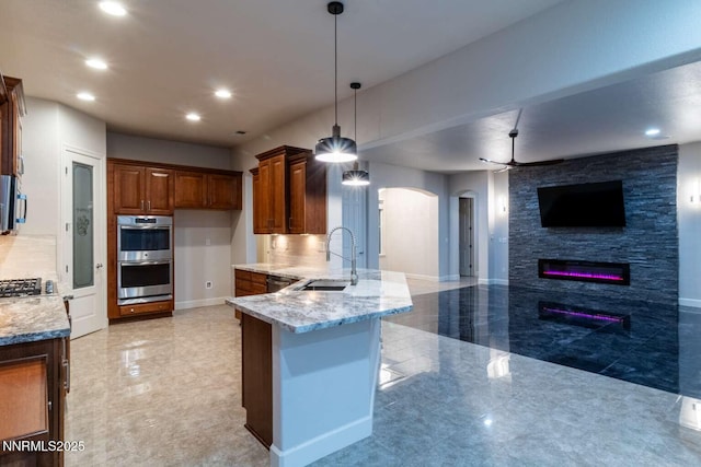 4525 Cobra Dr, Sparks, NV 89436 - kitchen with appliances with stainless steel finishes, arched walkways, open floor plan, a peninsula, and light stone countertops