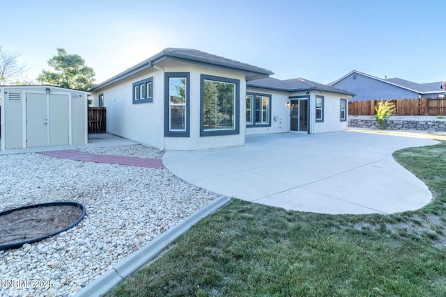 4525 Cobra Dr, Sparks, NV 89436 - back of property with a storage unit, a fenced backyard, stucco siding, and a patio area