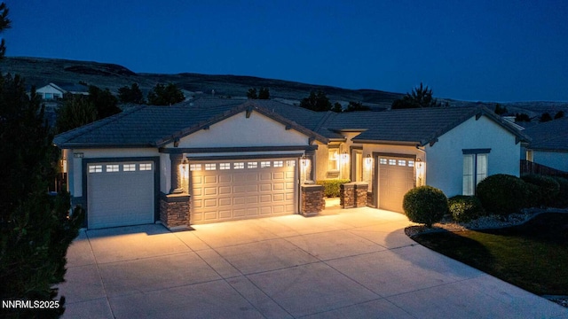 4525 Cobra Dr, Sparks, NV 89436 - view of front of house with an attached garage, stucco siding, concrete driveway, and stone siding