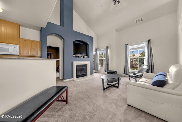17000 Wedge Pkwy Unit 1221, Reno, NV 89511 - living room featuring high vaulted ceiling, light colored carpet, and a glass covered fireplace