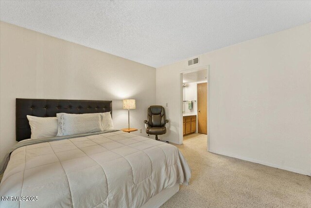 3095 Lakeside Dr # 103, Reno, NV 89509 - bedroom featuring light carpet, ensuite bathroom, and a textured ceiling