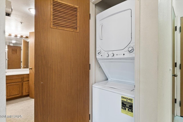 3095 Lakeside Dr # 103, Reno, NV 89509 - washroom with stacked washer and clothes dryer and a textured ceiling