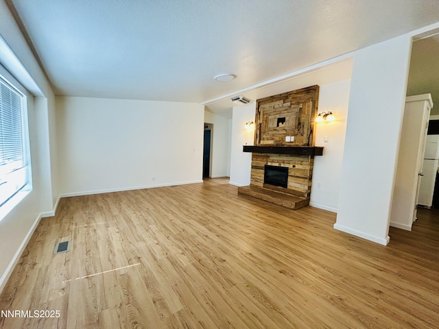4040 Placer Way, Winnemucca, NV 89445 - unfurnished living room featuring a stone fireplace and light wood-style flooring