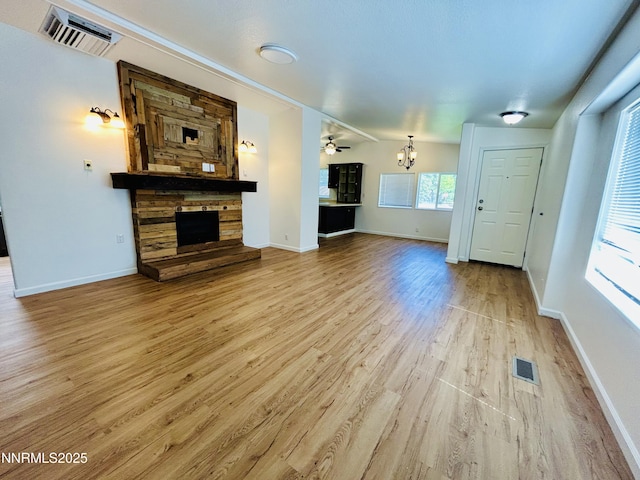 4040 Placer Way, Winnemucca, NV 89445 - unfurnished living room featuring a chandelier, a stone fireplace, light wood finished floors, and ceiling fan