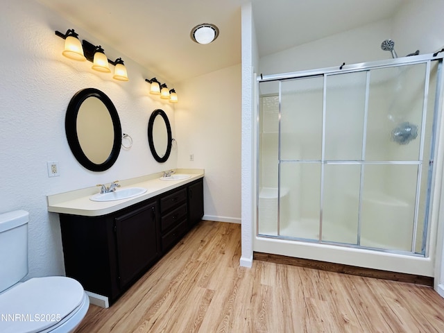 4040 Placer Way, Winnemucca, NV 89445 - bathroom featuring wood finished floors, double vanity, an enclosed shower, and lofted ceiling