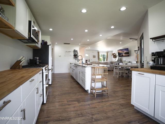 5875 Brooke Dr, Winnemucca, NV 89445 - kitchen with wooden counters, range with two ovens, open floor plan, stainless steel microwave, and dark wood-type flooring