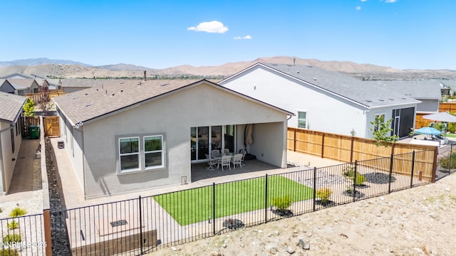7436 Rustic Towers Dr, Sparks, NV 89441 - rear view of house featuring stucco siding, a patio area, a mountain view, and a fenced backyard