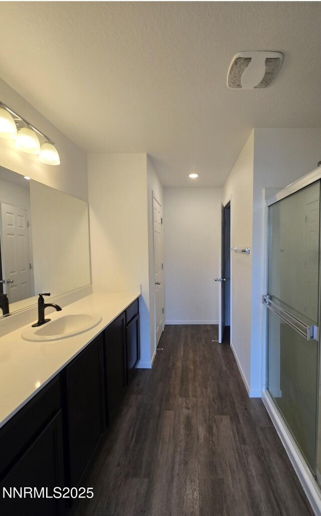 9615 Nautical Mile Rd, Reno, NV 89506 - bathroom with wood finished floors, vanity, a stall shower, a textured ceiling, and recessed lighting