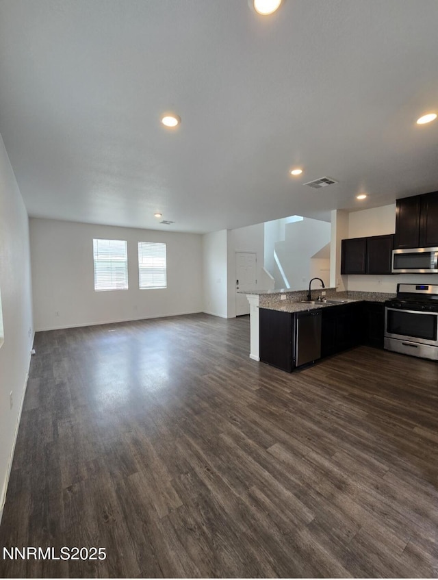 9615 Nautical Mile Rd, Reno, NV 89506 - kitchen featuring stainless steel appliances, open floor plan, dark wood finished floors, a peninsula, and recessed lighting
