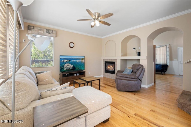 2865 Cintoia Dr, Sparks, NV 89434 - living room featuring wood finished floors, ornamental molding, ceiling fan, a tiled fireplace, and arched walkways