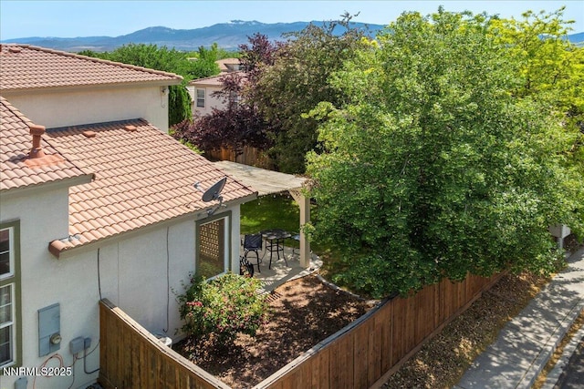 2865 Cintoia Dr, Sparks, NV 89434 - view of property exterior featuring a tile roof, a mountain view, and a patio