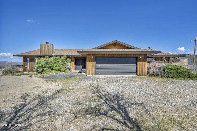 6200 Winnemucca Ranch Rd, Reno, NV 89510 - view of front of home featuring a chimney, an attached garage, and gravel driveway