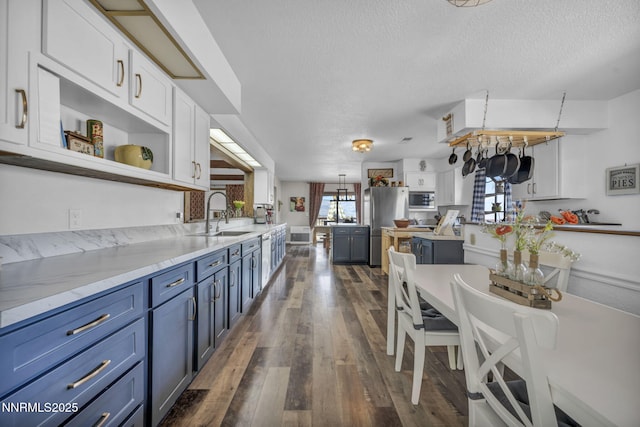 6200 Winnemucca Ranch Rd, Reno, NV 89510 - kitchen with blue cabinetry, white cabinetry, a textured ceiling, open shelves, and appliances with stainless steel finishes