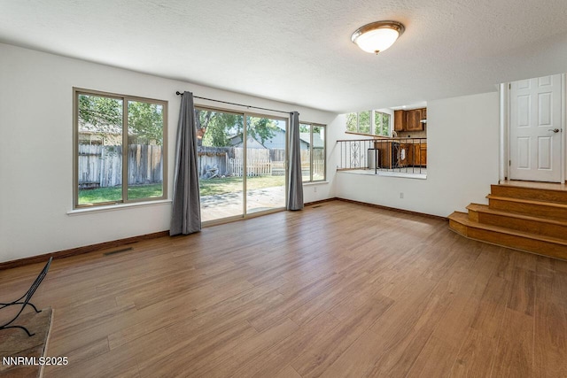 1245 Junction Ct, Sparks, NV 89434 - unfurnished living room with light wood finished floors, stairway, and a textured ceiling