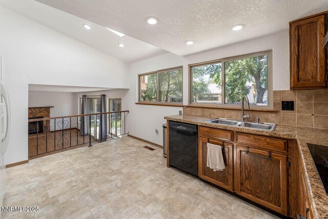1245 Junction Ct, Sparks, NV 89434 - kitchen with dishwasher, vaulted ceiling, a textured ceiling, recessed lighting, and brown cabinetry