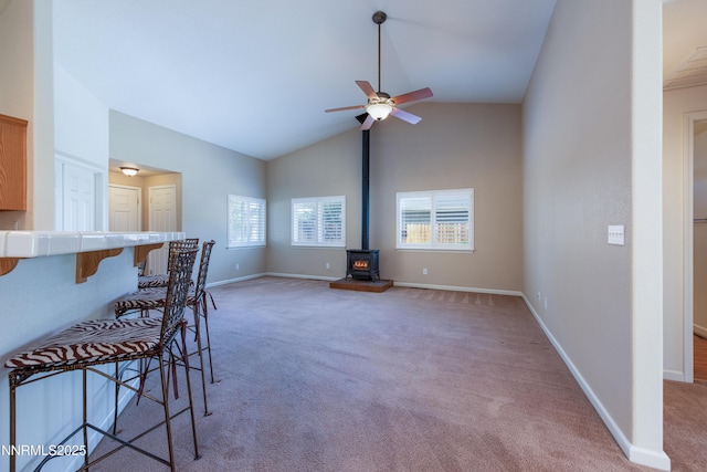 1421 Chiltern Ct, Gardnerville, NV 89410 - living area with a wood stove, light colored carpet, ceiling fan, and high vaulted ceiling