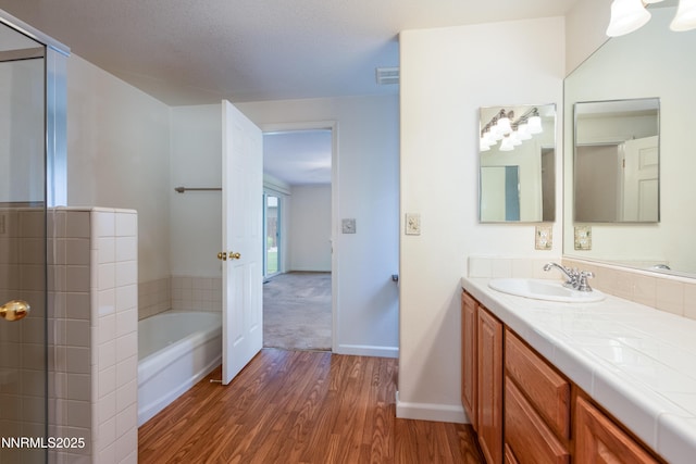 1421 Chiltern Ct, Gardnerville, NV 89410 - bathroom featuring wood finished floors, vanity, a garden tub, and a shower with shower door