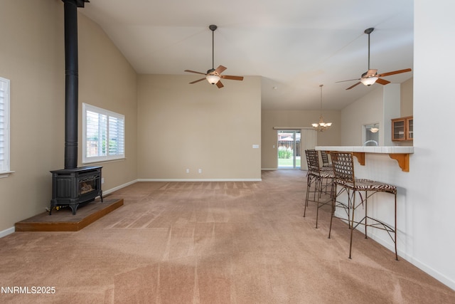 1421 Chiltern Ct, Gardnerville, NV 89410 - living area with a ceiling fan, a wood stove, light colored carpet, and high vaulted ceiling