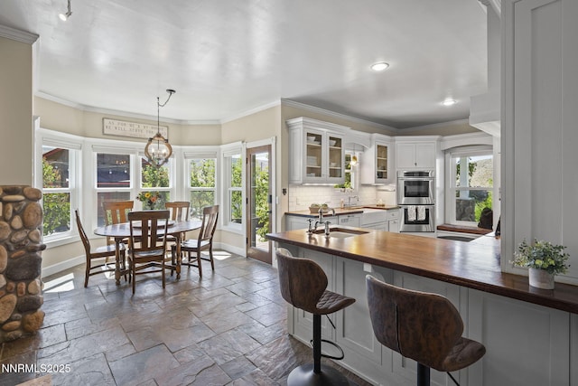 5 Connie Way, Reno, NV 89521 - kitchen with stainless steel double oven, butcher block countertops, stone tile floors, glass insert cabinets, and tasteful backsplash