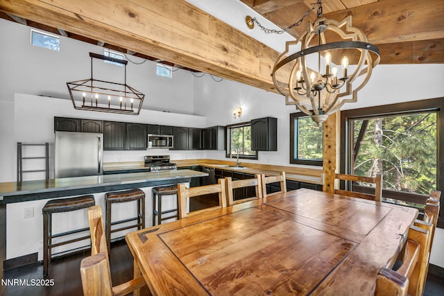 638 N Martin Dr, Zephyr Cove, NV 89448 - dining space featuring high vaulted ceiling, a chandelier, beam ceiling, plenty of natural light, and dark wood-style flooring