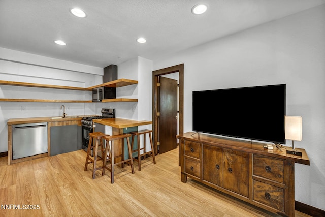 638 N Martin Dr, Zephyr Cove, NV 89448 - kitchen with appliances with stainless steel finishes, butcher block countertops, open shelves, light wood-style flooring, and recessed lighting