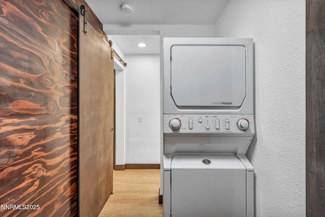 638 N Martin Dr, Zephyr Cove, NV 89448 - laundry area featuring a barn door, stacked washer and clothes dryer, wood finished floors, and a textured wall