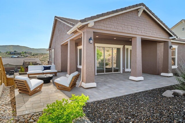 435 Gooseberry Dr, Reno, NV 89523 - back of house featuring an outdoor living space with a fire pit, a patio, stucco siding, and a mountain view