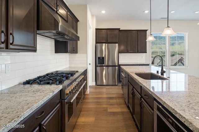 435 Gooseberry Dr, Reno, NV 89523 - kitchen featuring stainless steel appliances, range hood, dark wood-style flooring, dark brown cabinets, and light stone countertops