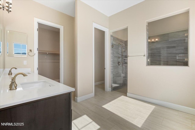 435 Gooseberry Dr, Reno, NV 89523 - bathroom with a stall shower, double vanity, a walk in closet, and wood finished floors