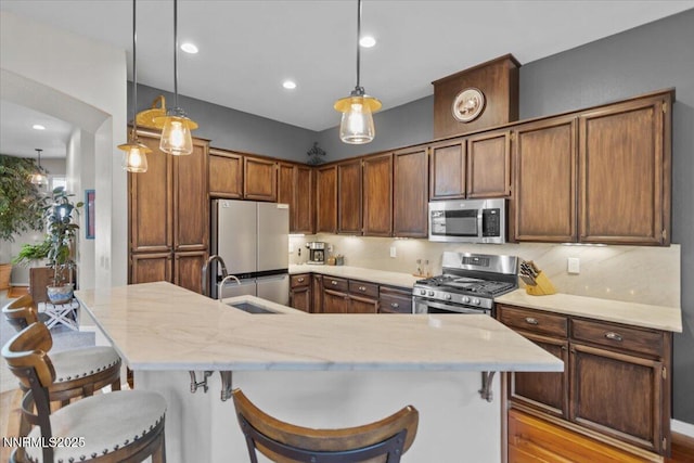 3215 Epic Ave, Reno, NV 89512 - kitchen with stainless steel appliances, a kitchen bar, decorative light fixtures, an island with sink, and recessed lighting