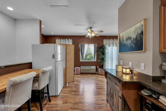 1236 Victorian Plaza Cir, Sparks, NV 89431 - kitchen featuring freestanding refrigerator, a wall mounted AC, light wood finished floors, dark countertops, and a ceiling fan