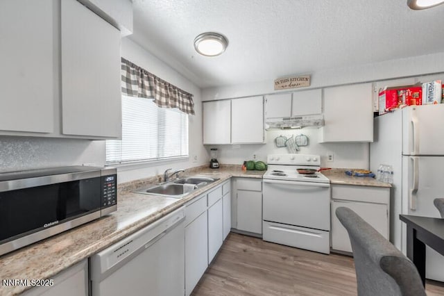 1412 E 9th St Unit 7, Reno, NV 89512 - kitchen featuring white appliances, under cabinet range hood, light countertops, light wood-type flooring, and white cabinetry