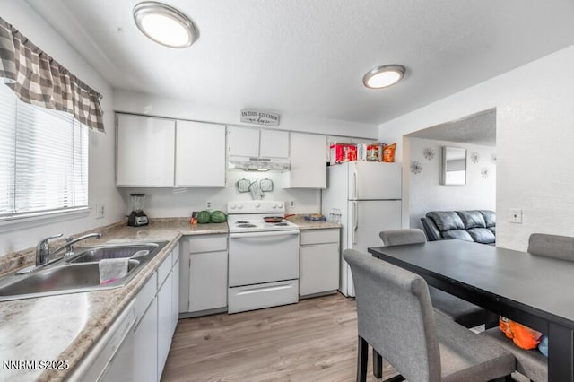 1412 E 9th St Unit 7, Reno, NV 89512 - kitchen with white appliances, under cabinet range hood, light wood-type flooring, white cabinets, and light countertops