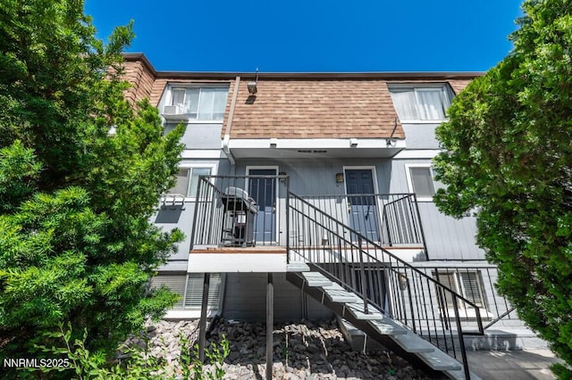 1412 E 9th St Unit 7, Reno, NV 89512 - back of property featuring stairway, a shingled roof, and mansard roof