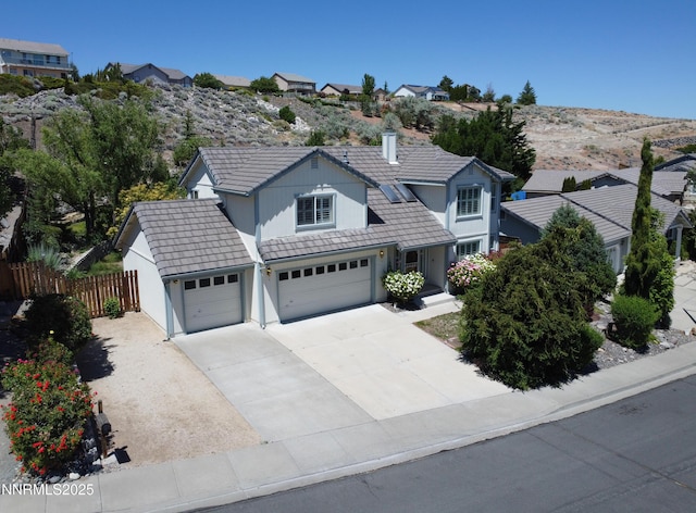 979 University Ridge Dr, Reno, NV 89512 - traditional home with a tiled roof, driveway, stucco siding, an attached garage, and a chimney