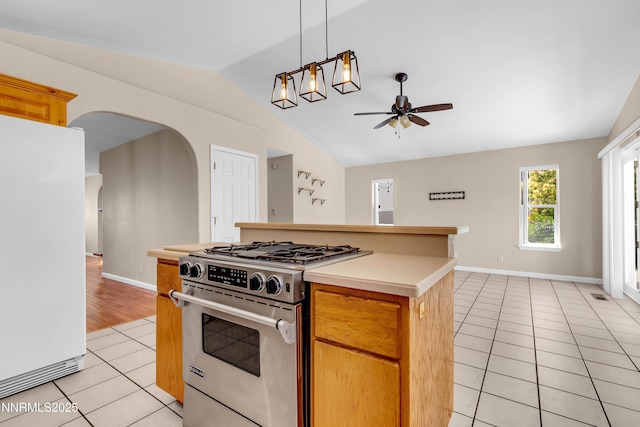 979 University Ridge Dr, Reno, NV 89512 - kitchen featuring gas stove, freestanding refrigerator, vaulted ceiling, light tile patterned floors, and ceiling fan