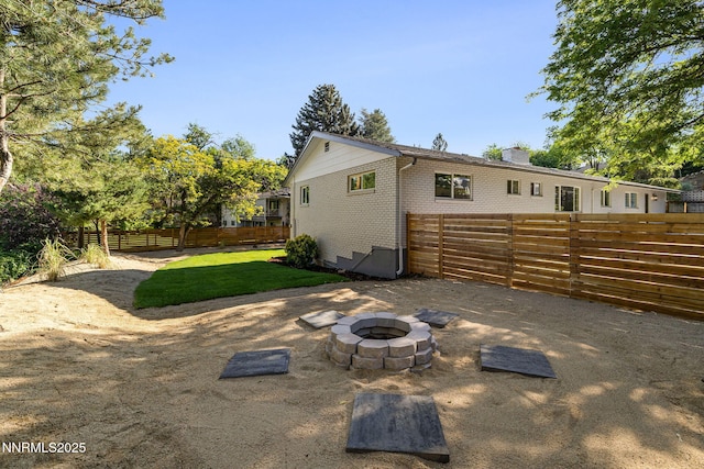 50 Moore Ln, Reno, NV 89509 - rear view of property with brick siding, an outdoor fire pit, and a chimney