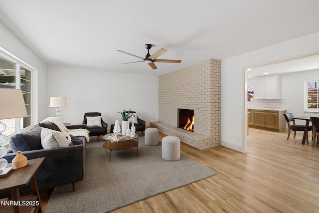 50 Moore Ln, Reno, NV 89509 - living room with light wood finished floors, a ceiling fan, and a brick fireplace