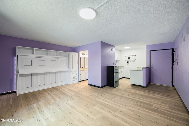 2450 Lymbery St Unit 233, Reno, NV 89509 - unfurnished living room featuring a textured ceiling and light wood-style flooring