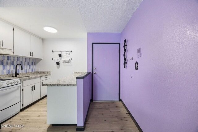 2450 Lymbery St Unit 233, Reno, NV 89509 - kitchen featuring white stove, light wood finished floors, extractor fan, white cabinets, and a textured ceiling