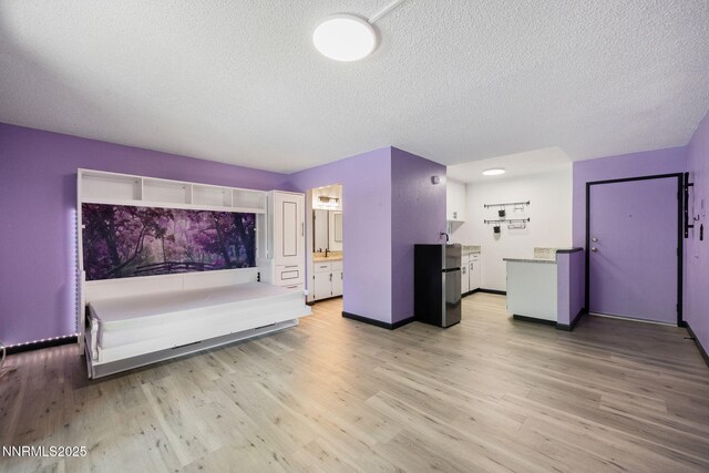 2450 Lymbery St Unit 233, Reno, NV 89509 - unfurnished living room with a textured ceiling and light wood finished floors