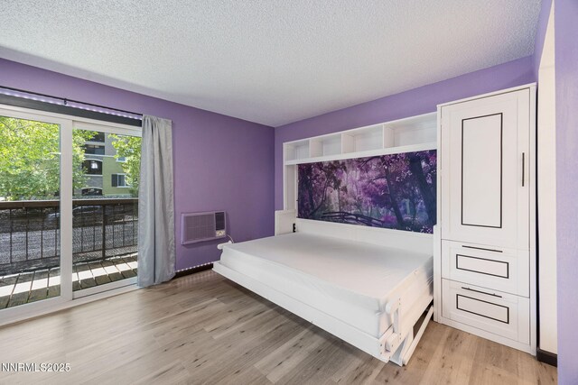 2450 Lymbery St Unit 233, Reno, NV 89509 - bedroom featuring light wood-type flooring, an AC wall unit, and a textured ceiling