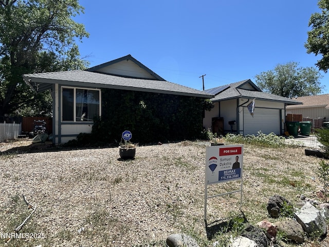 1655 Byrd Dr, Sparks, NV 89431 - view of front facade with a garage, a shingled roof, and solar panels