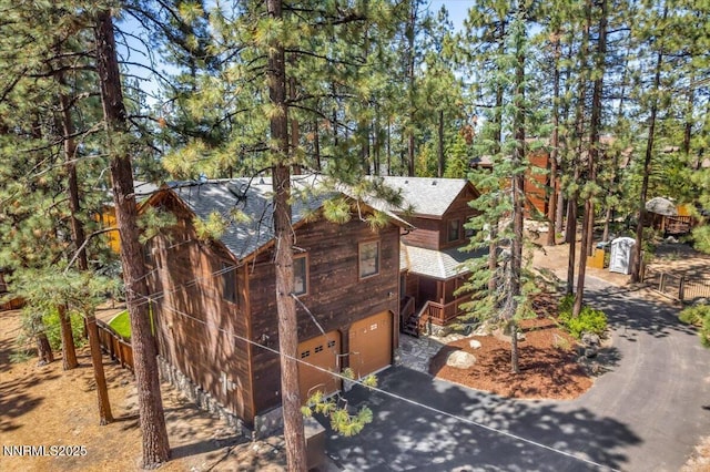 458 Center St, Zephyr Cove, NV 89448 - view of side of property featuring a garage, a shingled roof, and asphalt driveway