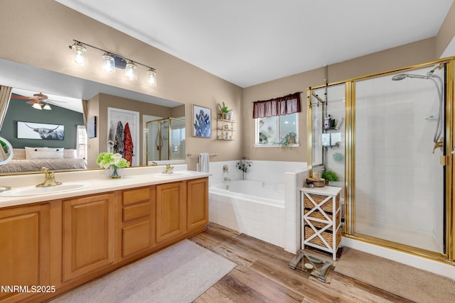 1450 Talon Ct, Spanish Springs, NV 89441 - bathroom with wood finished floors, a stall shower, a garden tub, connected bathroom, and double vanity